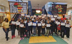 Elementary students standing and holding certificates